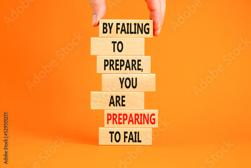 Preparing symbol. Concept words By failing to prepare you are preparing to fail on wooden blocks on a beautiful orange background. Businessman hand. Business motivational and preparing concept.