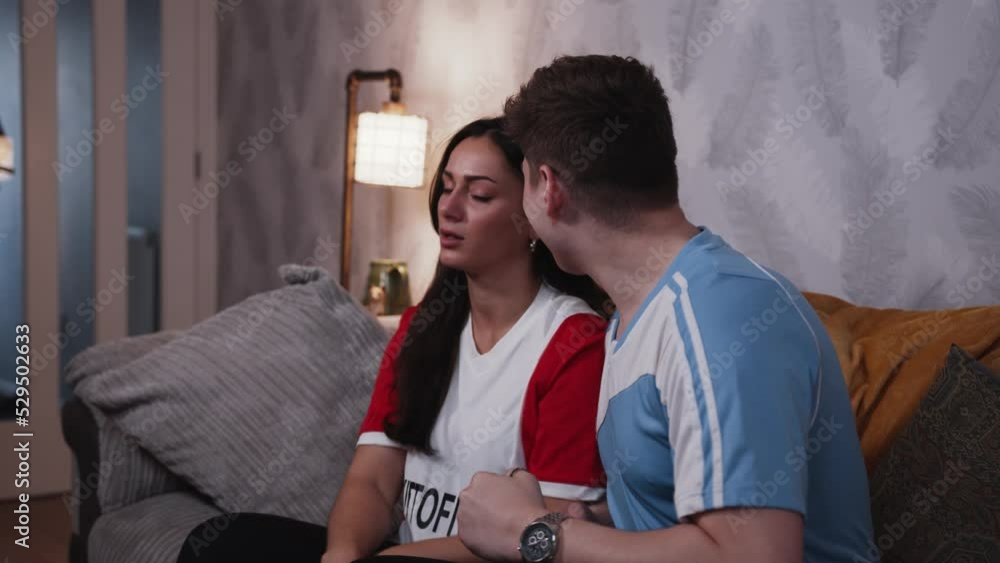 Rival fans watch football together male blue fan celebrates and gloats in slow motion
