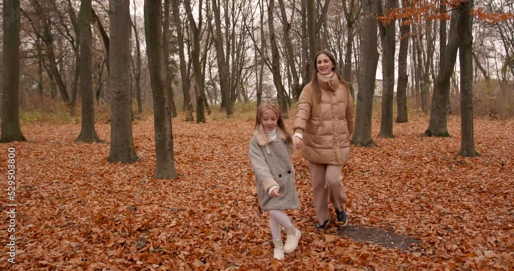 Mother and daughter walking in the autumn forest Mother and daughter walking in the autumn forest