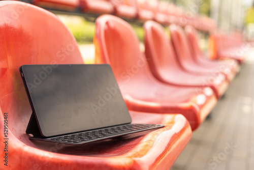 Fotografie tablet on empty tribune of stadium on daytime