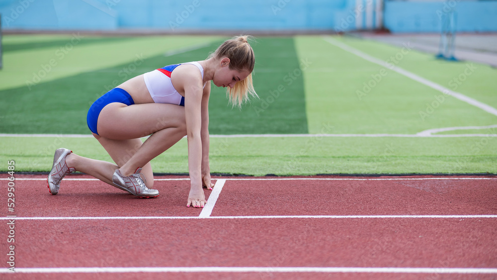 Female runner in the stadium is ready to race.