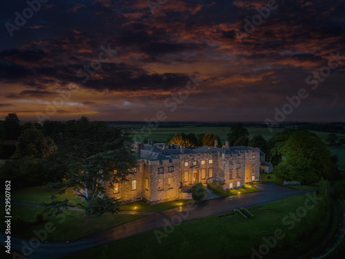 Hazlewood Castle, North Yorkshire historic castle at night. Aerial drone photograph of the front of the castle and moody sky. Close to Leeds and York, Yorkshire, england, united kingdom photo