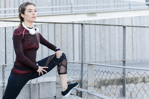 woman stretching resting after running and jogging in a park with sportswear photo