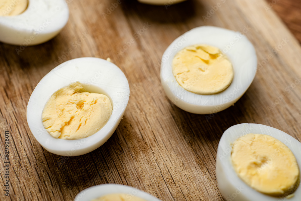 Halves of boiled chicken eggs on a wooden background. Halves of boiled chicken eggs on a wooden background.