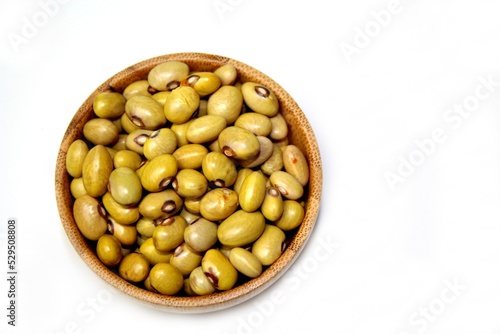 Yellow Ball Beans (Phaseolus vulgaris) in a wooden bowl, isolated, top view on a white background.