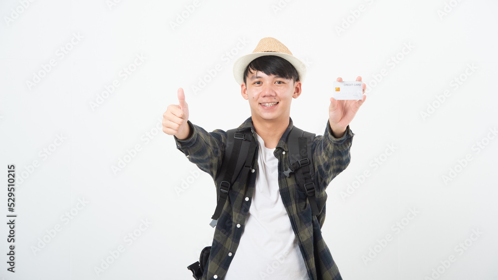 Travel budget concept. Happy young man with tourist backpack holding credit card and showing thumb up over white studio background. Traveler planning adventure Travel budget concept. Happy young man with tourist backpack holding credit card and showing thumb up over white studio background. Traveler planning adventure