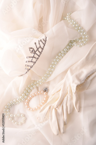 crown gloves and pearls on white