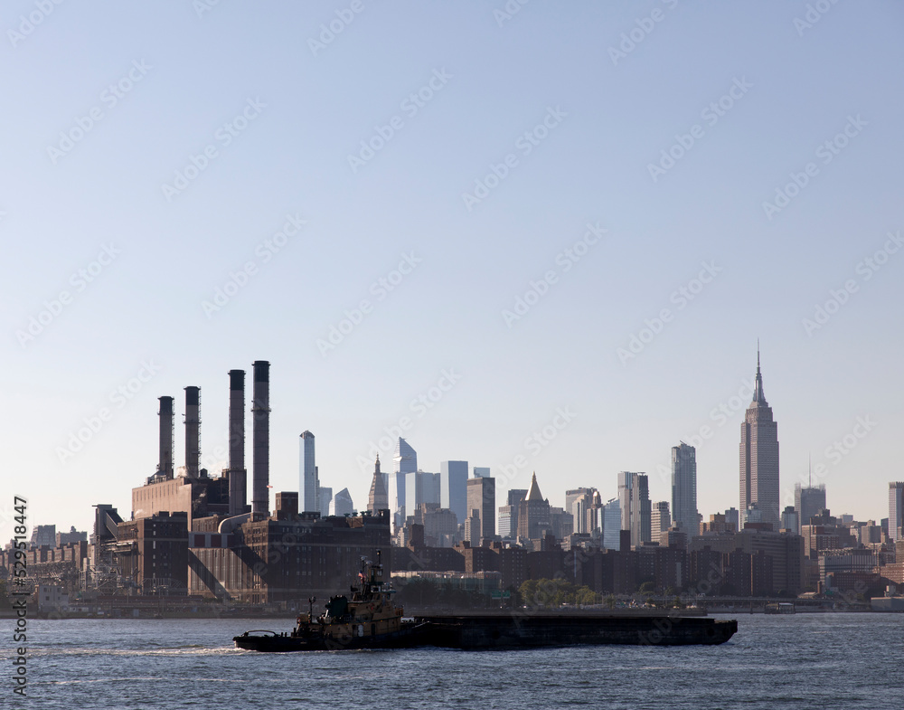 Tugboat barge on East River with view of midtown Manhattan
