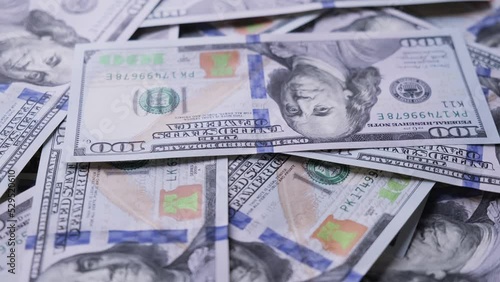 Man counting american one hundred dollar paper money at rotating table. Cash money banknotes. Finance and investment concept. Pile of american dollars. Close-up in 4K, UHD