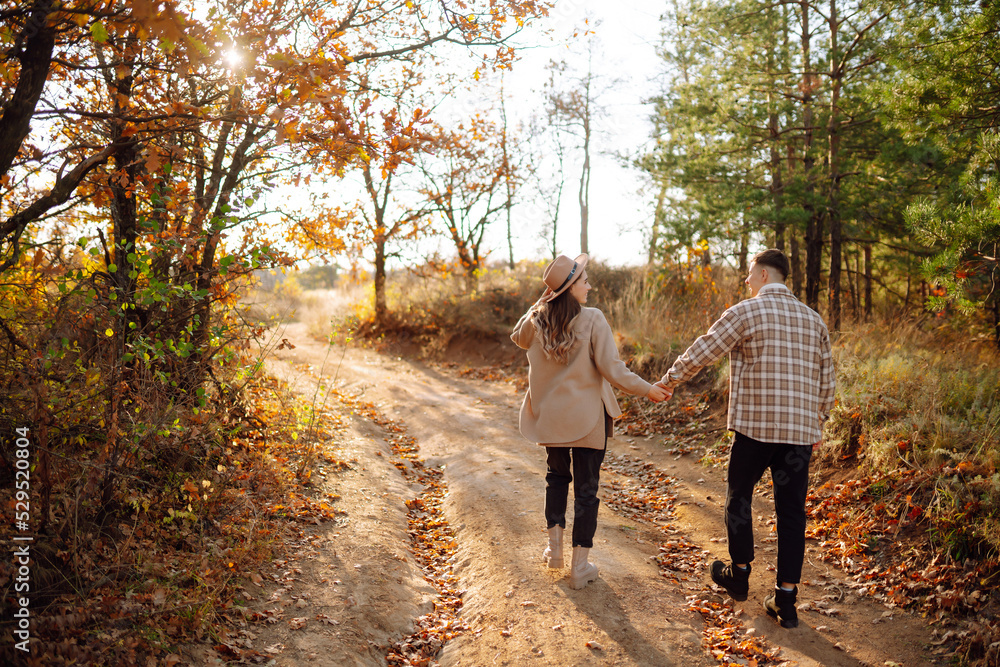 Obraz premium Stylish couple walking and enjoying autumn weather. People, lifestyle, relaxation and vacations concept. Autumn Fashion, style concept.