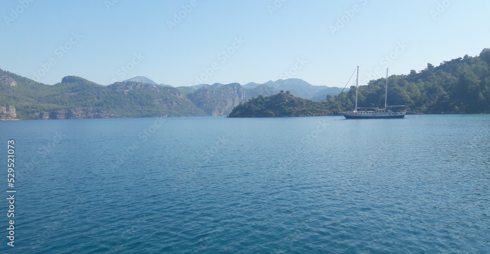 Blue sea against the background of rocks, mountains and sky. Beautiful natural landscape. Travel, vacation. Aegean Islands, Turkey. Blue sea against the background of rocks, mountains and sky. Beautiful natural landscape. Travel, vacation. Aegean Islands, Turkey.