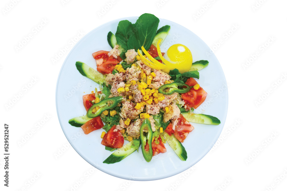 Overhead view of tuna fish salad with tomatoes, arugula, corn served on white plate