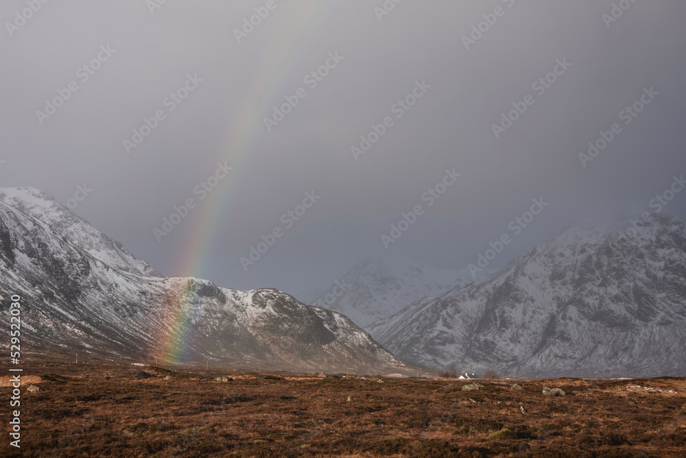 Majestic landscape image of vibrant rainbow in front of mountains in Scottish Highlands Rannoch Moor Stob Dearg