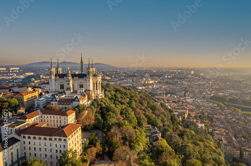 The drone aerial view of The Basilica of Notre-Dame de Fourvière and Metallic tower at sunrise in Lyon, France.