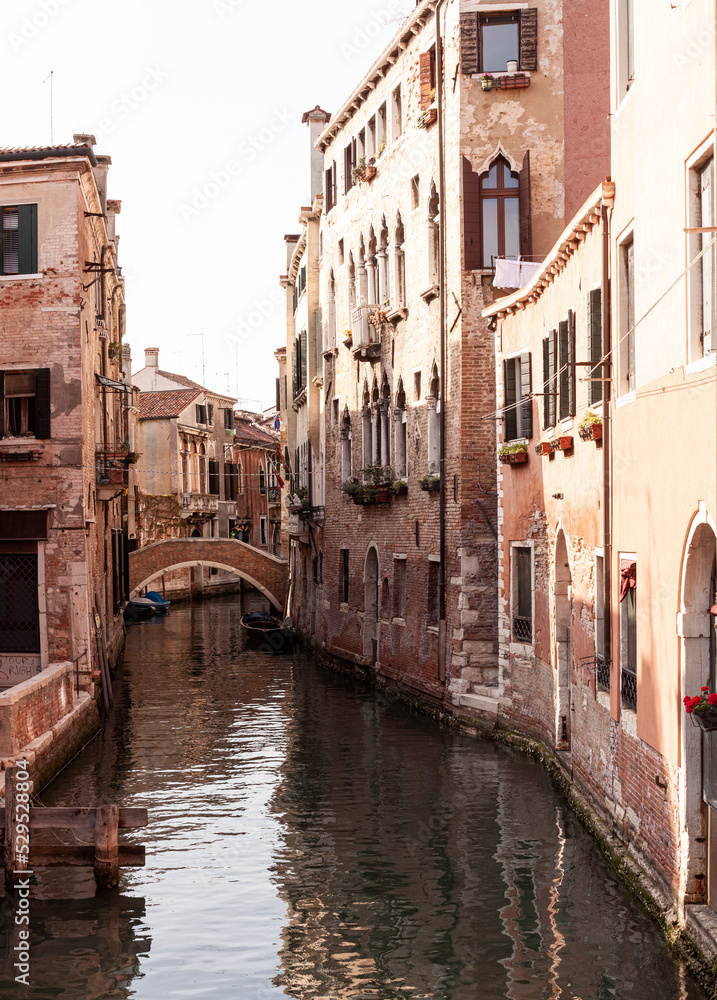 Typical bridge made with red bricks on the typical canal in Venice