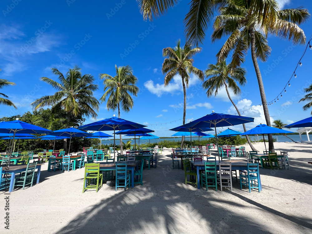 A typical beach restaurant with colorful tables, chairs and umbrellas in the Florida Keys.