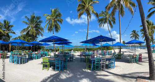 A typical beach restaurant with colorful tables, chairs and umbrellas in the Florida Keys.