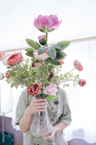 Wallpaper Mural Teenager girl holding a bunch of pink and red peonies in vase  Torontodigital.ca
