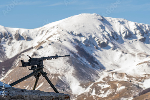 Fucile ad alta precisione in primo piano e montagne innevate sullo sfondo photo