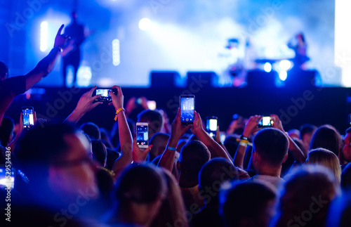 Obraz na płótnie Using a smartphone in a public event, live music festival