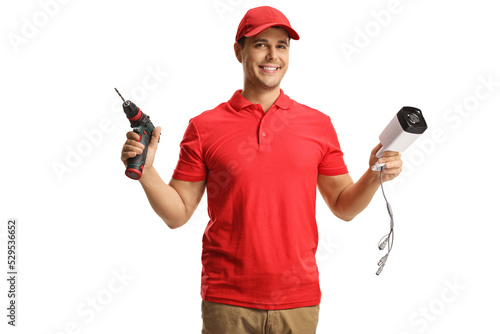 Worker holding a surveillance camera and a drill machine