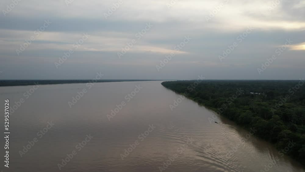 Aerial panorama view of the silty Amazon River and a water taxi, villages and eco tourism lodges Aerial panorama view of the silty Amazon River and a water taxi, villages and eco tourism lodges