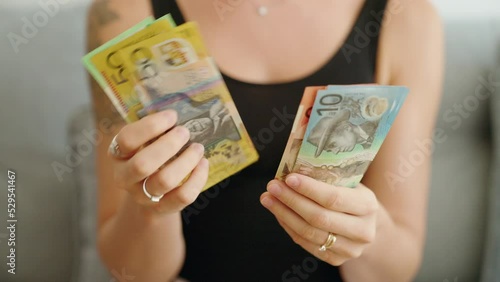 Young woman counting australia dollars banknotes at home photo