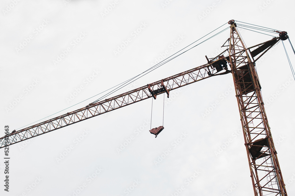 Construction crane on a white sky background. Bottom view. Construction crane on a white sky background. Bottom view.