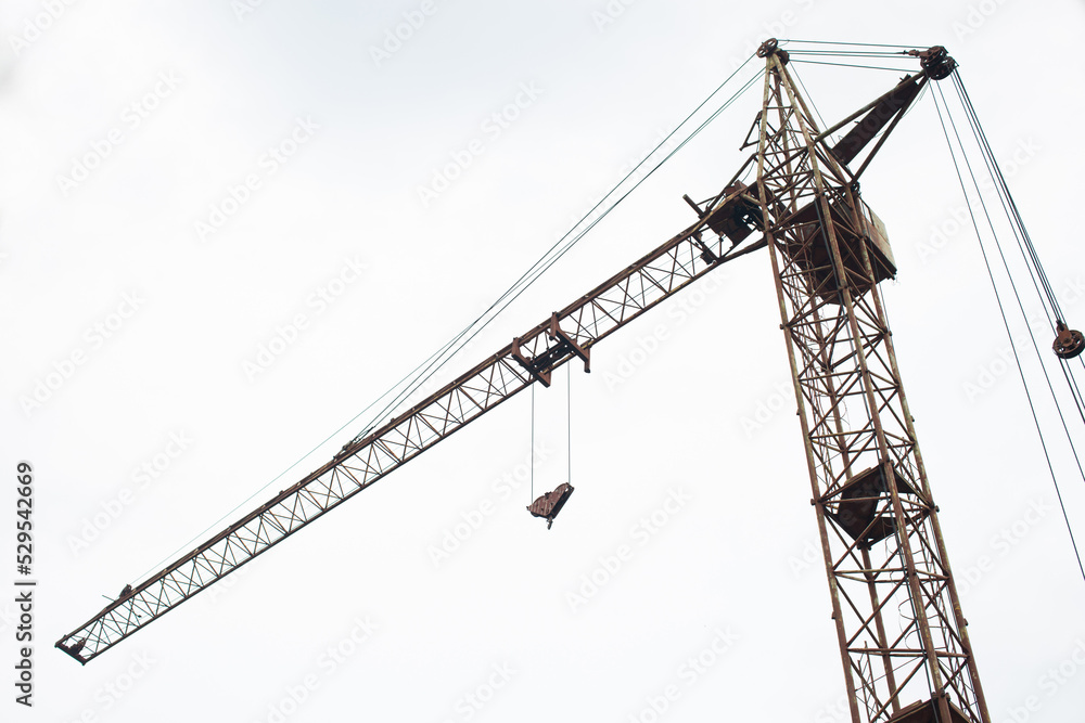 Construction crane on a white sky background. Bottom view. Construction crane on a white sky background. Bottom view.