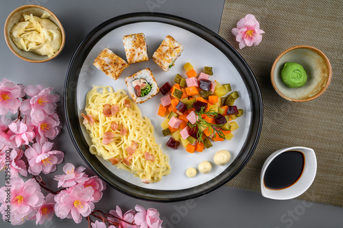 Japanese dish of rolls, salad and pasta on a plate