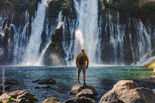 Man traveler looking on the beautiful waterfall photo