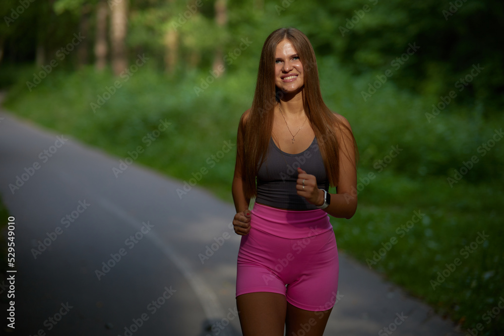 Sexy woman with sexy body in stylish sportswear jogger in park at sunset. Athletic girl with running in forest on summer day. Sexy woman with sexy body in stylish sportswear jogger in park at sunset. Athletic girl with running in forest on summer day.