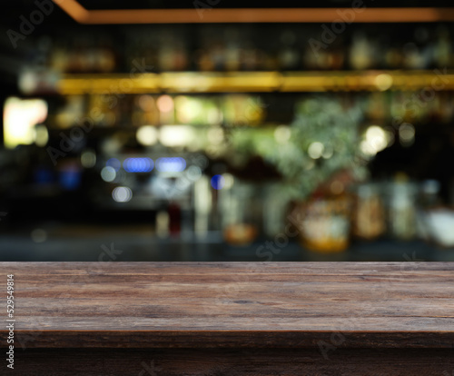 Empty wooden surface and blurred view of bar interior. Space for design