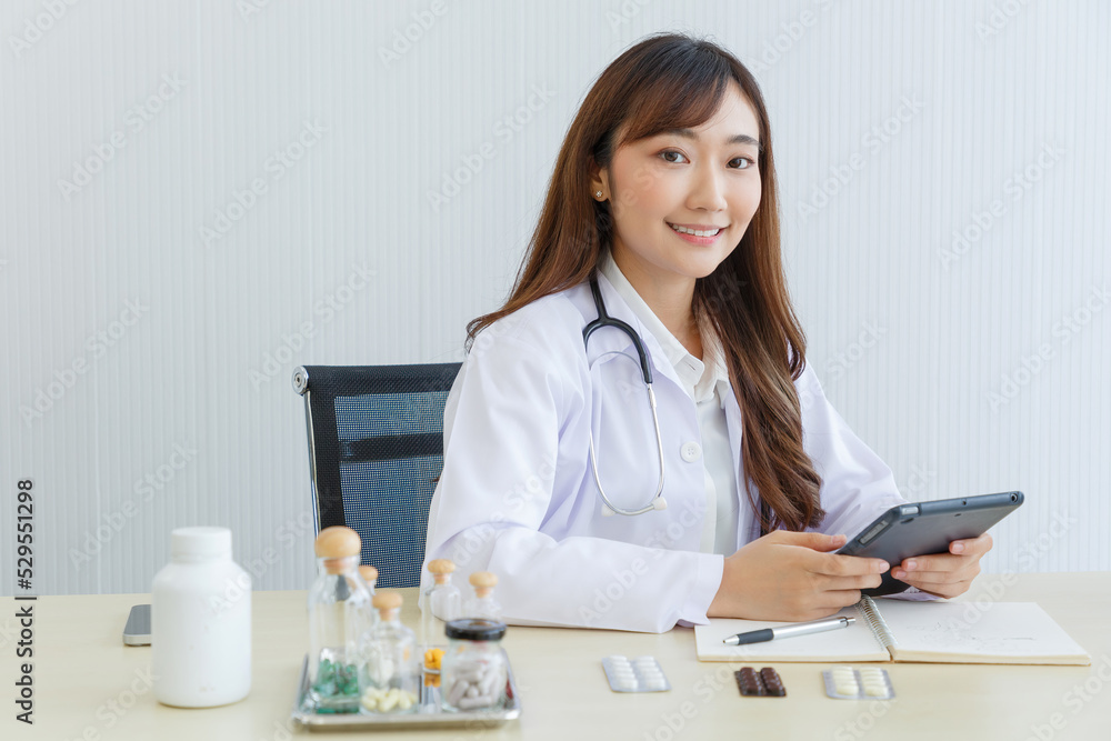 Portrait of Female doctor.Female doctor while consult and .explain. Doctor using tablet at table in examination room. Portrait of Female doctor.Female doctor while consult and .explain. Doctor using tablet at table in examination room.