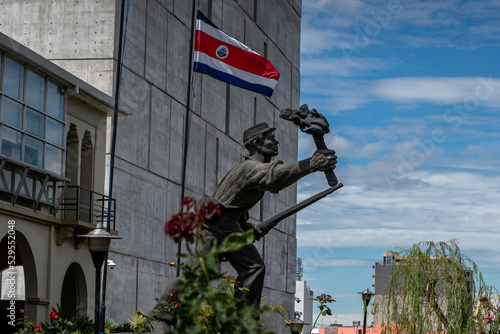 Closeup view of the statue -monument of the national hero Juan Santamaria- next to the Costa Rica Flag