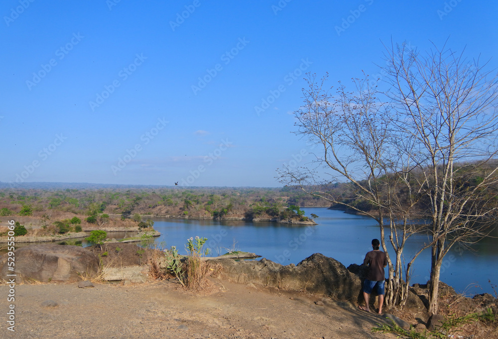 A Man walking around Waduk Bajulmati in Situbondo, East Java, Indonesia. A Man walking around Waduk Bajulmati in Situbondo, East Java, Indonesia.