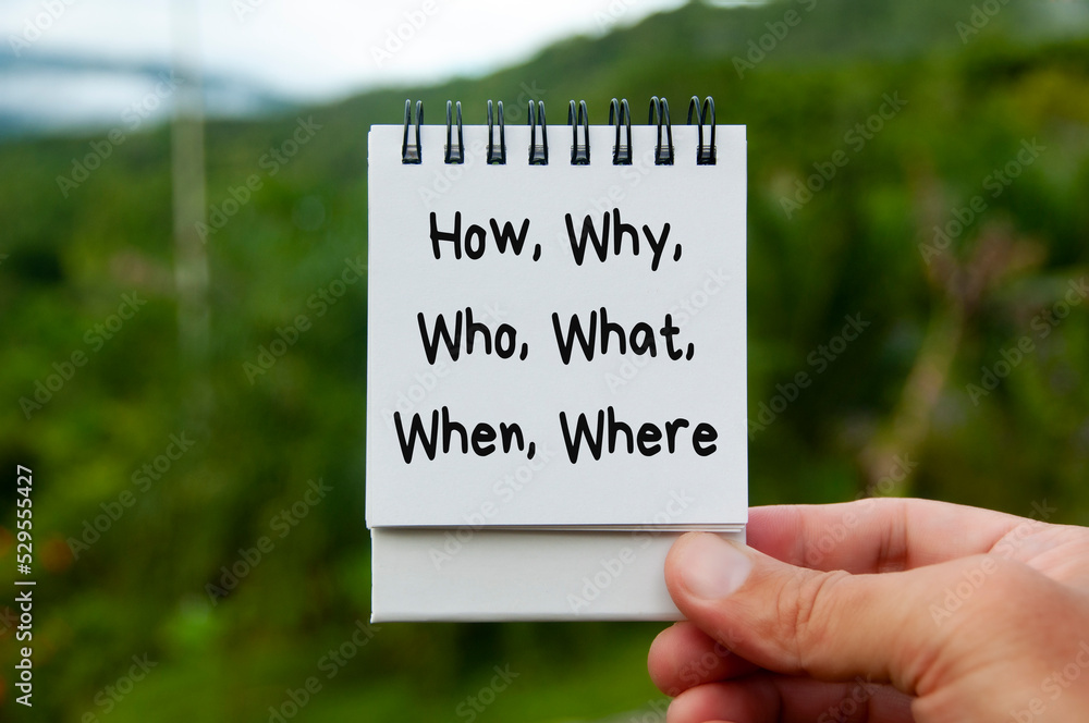 How, why, who, what, when and where text on calendar pad with blurred ...