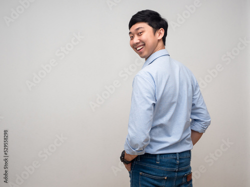 Foto Positive man blue shirt happy smile turn back to looking at camera