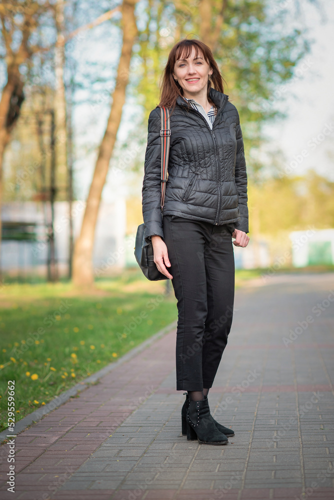 Fototapeta premium Portrait of a young beautiful dark-haired girl in an autumn park.