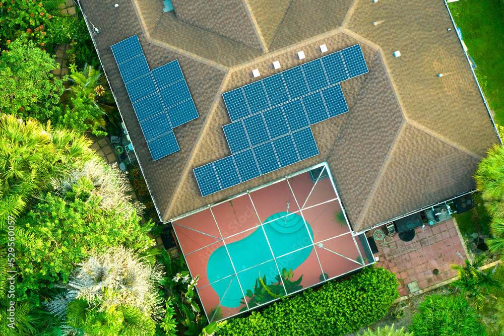 Aerial view of typical american building roof with rows of blue solar photovoltaic panels for producing clean ecological electric energy. Renewable electricity with zero emission concept