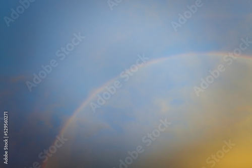 Colorful round rainbow against blue evening sky after heavy thunderstorm