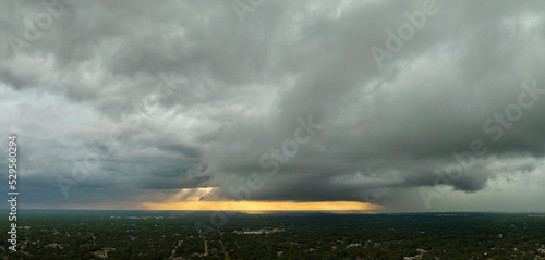 Dark stormy clouds forming on gloomy sky before heavy rainfall over suburban town area