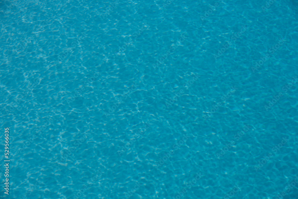 Background of blue water in swimming pool with sun reflection, ripple water wave in pool. Clear water background. Background of blue water in swimming pool with sun reflection, ripple water wave in pool. Clear water background.
