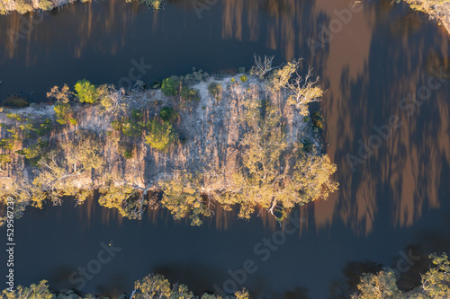 Aerial view of a hairpin bend in a murky river lined with gumtrees photo