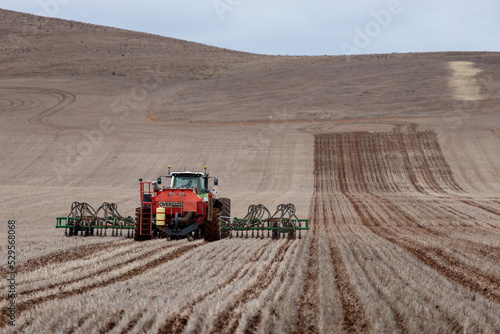 tractor and air seeder sowing a paddock photo