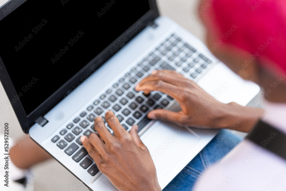 Fototapeta premium Top view of hands of a woman using a laptop