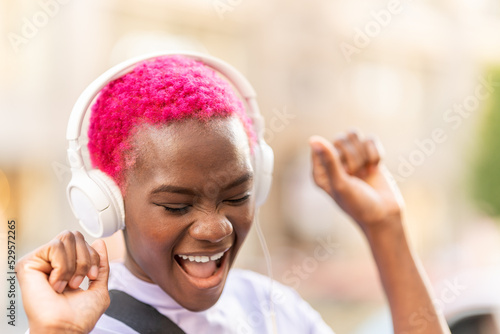 African woman dancing while listening to music outdoors