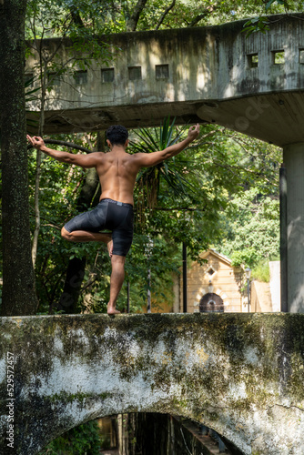 latin american man doing yoga posture, yoga posture, Bee backwards Prsthatah Brahmara, forest