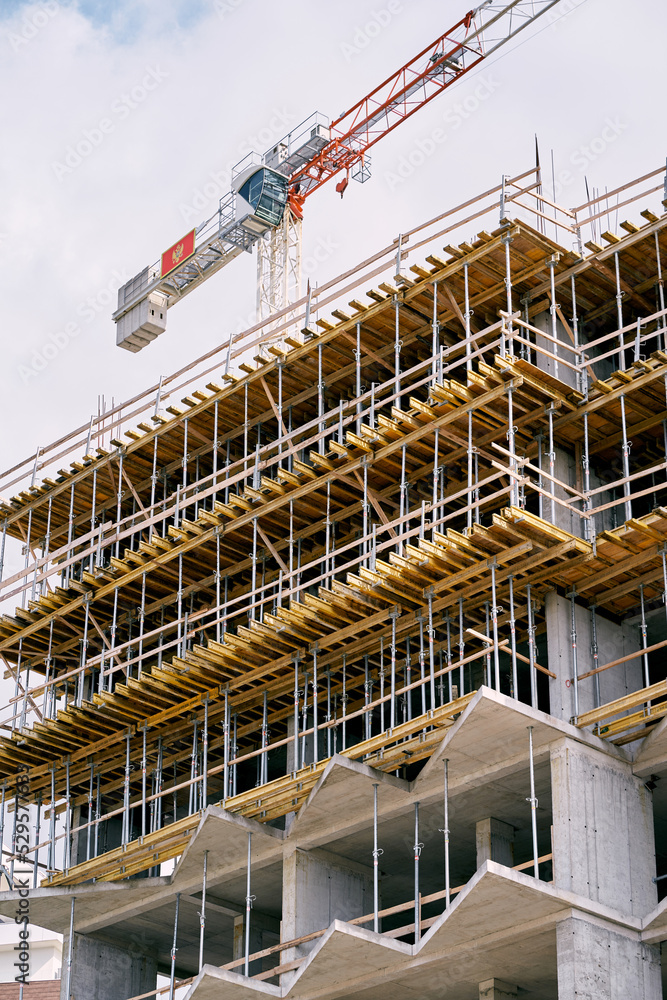 Tower crane rises above the construction of a multi-storey building. High quality photo