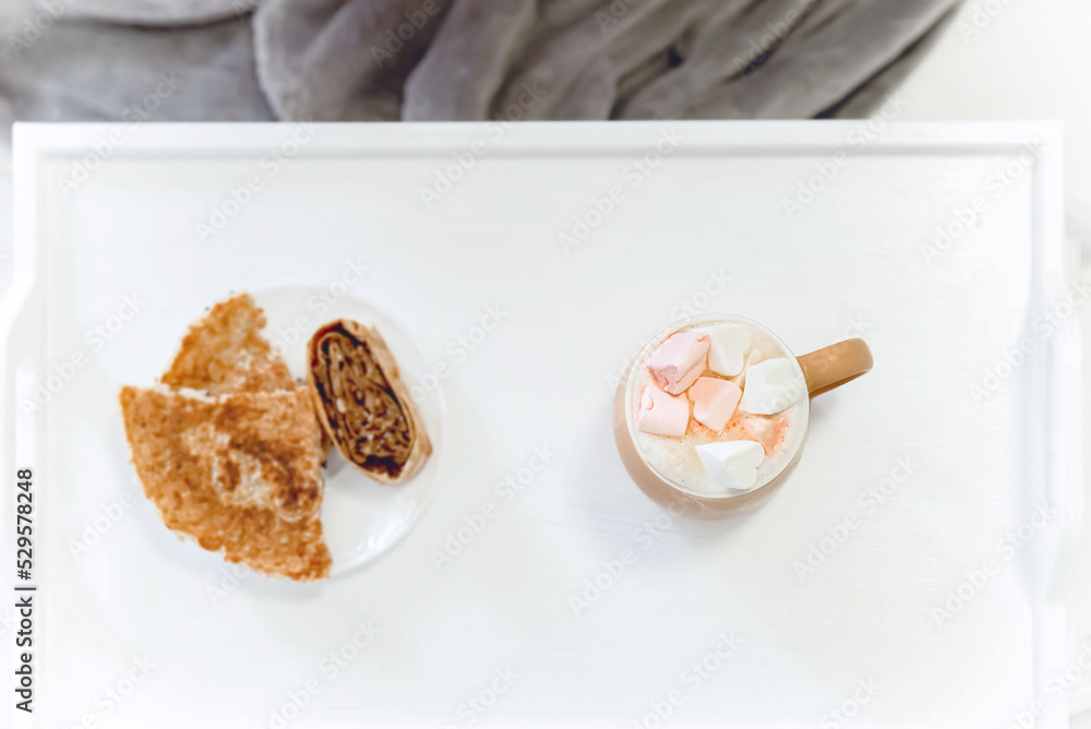 a cup of coffee with marshmallows with breakfast on a white tray on a white background, a feeling of tenderness, morning and security, selective focus a cup of coffee with marshmallows with breakfast on a white tray on a white background, a feeling of tenderness, morning and security, selective focus
